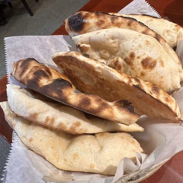 A basket of freshly baked, charred naan bread from Masala Indian Cuisine.